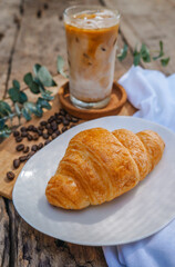 Croissant and hot coffee on a wooden table