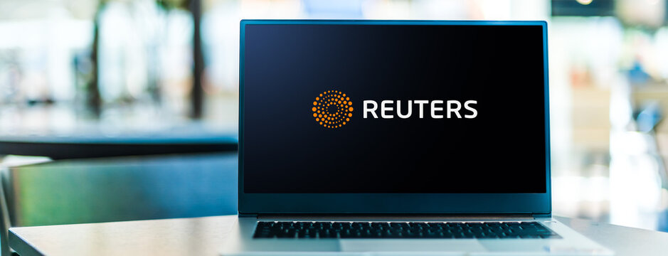 Laptop computer displaying logo of Reuters