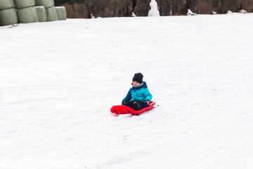 Fototapeta na wymiar boy with red sled in the snow