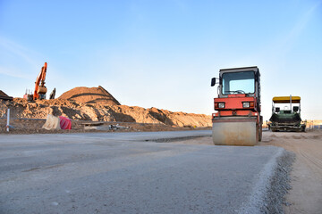 Asphalt paver machine during road work. Road Machinery at construction site for paving works. Screeding the sand for road concreting. Asphalt pavement is layered over concrete pavement. Road Surfacing