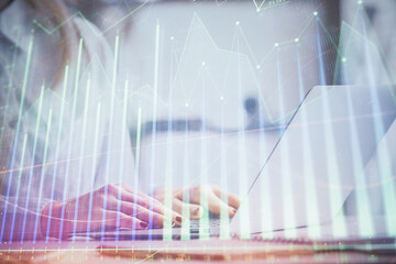 Double exposure of woman hands working on computer and forex graph hologram drawing. Financial analysis concept.