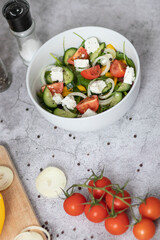 Green vegan salad made from a mixture of green leaves and vegetables.