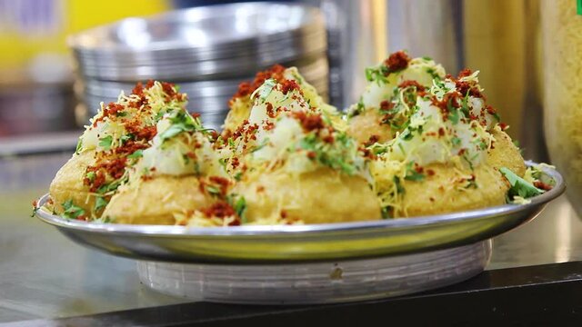 Closeup of Freshly Prepared Sev Batata Puri, an Indian fast food dish. Its made by filling puris with potato, tomatoes, onions and sweet, tangy tamarind and mint coriander chutneys. Mumbai, India 5199