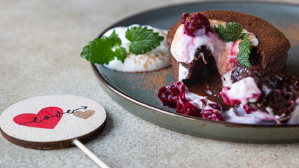 Traditional french chocolate cake with liquid filling served with cream, cherry and mint. Chocolate fondant. Chocolate Lava cake.