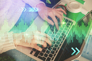 Double exposure of woman hands typing on computer and forex chart hologram drawing. Stock market invest concept.