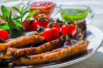 Fresh, homemade grilled beef skewers with vegetables and spices, with barbecue sauce and ketchup, on a white plate close-up