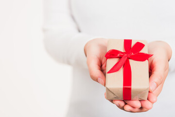 Valentine Day. Female beauty hands holding small gift package box present wrapped paper with ribbon...