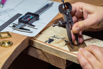 Custom jewelry making and drawing on a piece of metal.