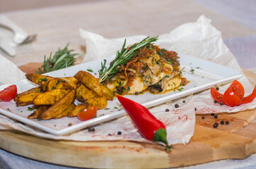 Chicken breast with mushroom sauce and French fries on a plate on the table.
