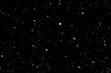 Bokeh of white snow on a black background. Snowfall - design element.