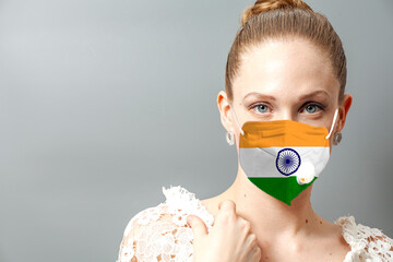 Portrait of young woman wearing face protective mask with India flag