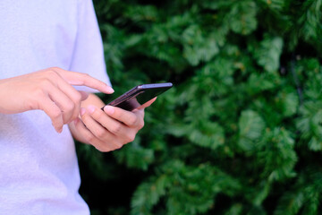Man holding smartphone with christmas tree background, Technology concept.