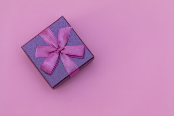 Purple gift box with ribbon on a lilac background. Composition for Valentine's Day. Flat lay, copy...