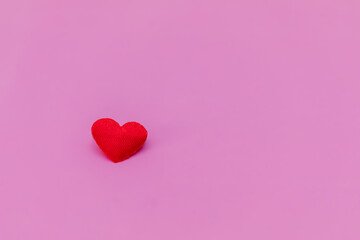Red heart on a pink background. Composition for Valentine's Day. Flat lay, copy space, top view.