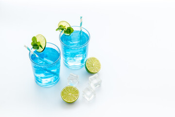 Blue beverage, iced alcohol cocktail drink with lime and mint