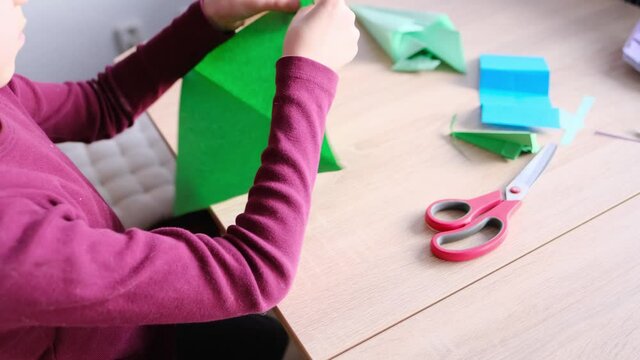 kid, boy holding model of dinosaur, folded from white paper using Japanese origami technique, concept of crafting crafts, hobbies, games, activities in room, development of fine motor skills