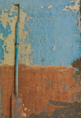 Aged multicolored wall with exterior pipe