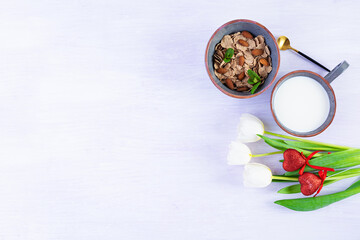 Spelt flakes with milk on breakfast. Light breakfast on Valentine's day with tulips and heart