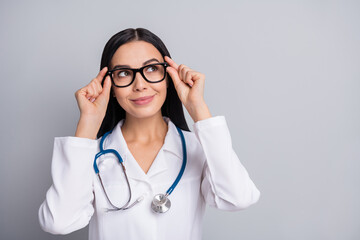 Photo of doctor lady look empty space wear stethoscope glasses white uniform isolated grey color background