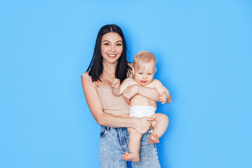 Mom plays in her arms with her son against a blue background. Education and care for the health of children