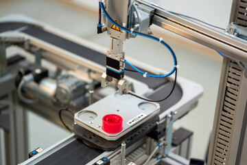 Industry 4.0 smart factory concept; artificial intelligence in production. Gripper picks up the product from the automated car. Selective focus.