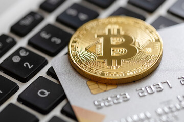 Credit card and bitcoin on the computer keyboard