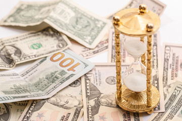 Hourglass and US dollar banknotes