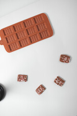 Homemade chocolate on a light background. Plastic confectionery molds for sweets