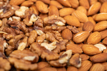 Almonds and walnuts scattered on the table. Close-up, selective focus.