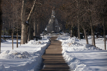 Road without snow inside the Buen Retiro public park, with a lot of accumulated snow, without...