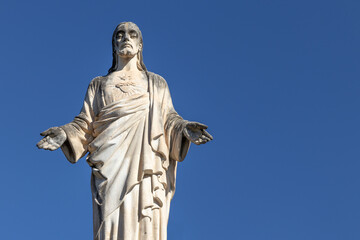 Cristo (Jesus Christ) antique statue in Sant Quirze del Valles, Spain. Clear blue sky background,...