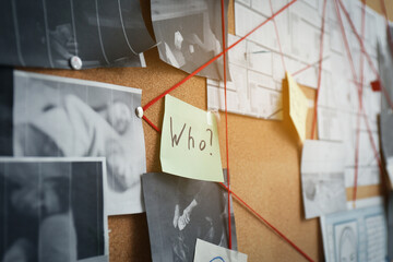 Detective board with sticker, crime scene photos and red threads, closeup