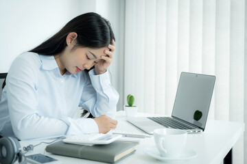 Sad Asian businesswoman employee unhappy working with bored on the laptop and chart in the office tired, Office Syndrome concept