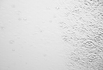 Monochrome image of the rain water drops on the glass surface of Norway criuse ship window