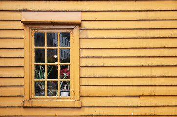 Window of yellow wooden house Bryggen street Bergen, Norway