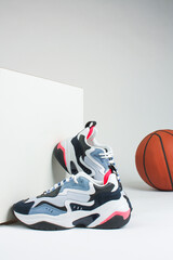 Women's large sneakers and a basketball on a white background.