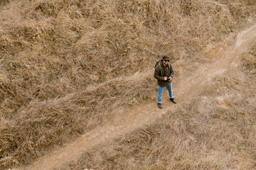 Naklejka premium Focused handsome photographer walking with digital camera