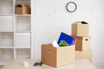 financial crisis, bankruptcy and moving day concept - moving boxes with things on table in modern office.