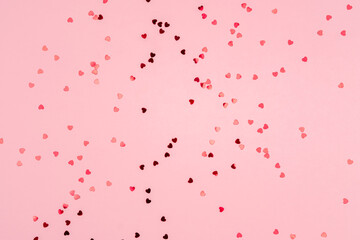 Fototapeta na wymiar Pink background with glitter hearts for valentine's day. 