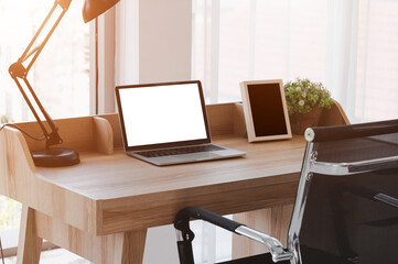 Notebook screen is blank Placed on the desk by the window The morning sun shines. working at home concept, working concept in office. Clipping path.
