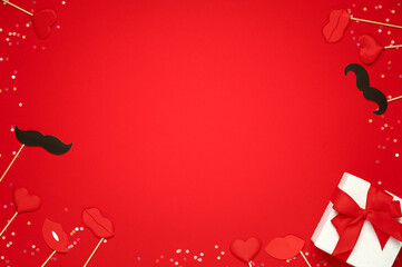 Gift box and soft hearts lips and paper moustache over red background. Template of Valentine's day
