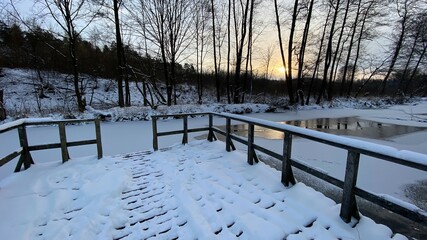 zimowy krajobraz częściowo zamarzniętej rzeki koło Włodawy dużo śniegu niebieskie niebo złota godzina  - obrazy, fototapety, plakaty