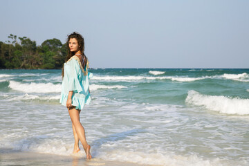 Young lovely woman is walking by the sea shore