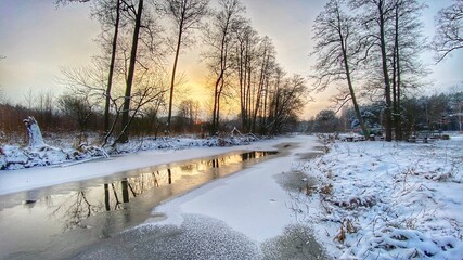 Fototapeta zimowy krajobraz częściowo zamarzniętej rzeki koło Włodawy dużo śniegu niebieskie niebo złota godzina  obraz
