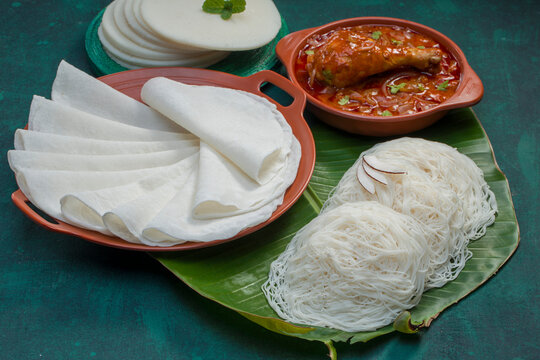 Chicken curry with pathir and ideyappam,a good combination of chicken curry with nice pathiri ,white pathiri and ideyappam arranged on dark green texture background.