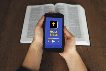 Woman hand hold and touch screen smart phone,cellphone in church over blurred bible holy and age...