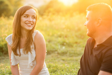 Fototapeta premium Couple lovers hugging and kissing in the park at sunset. Love, youth, happiness concept. 