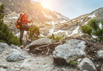 Woman hiker, hiking backpacker traveler camper walking on the top of mountain in sunny day under sun light. Beautiful mountain landscape view. Health care, authenticity, sense of balance and calmness.
