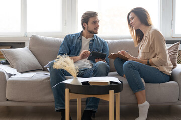 Photo of cheerful young couple analyzing their finances with documents