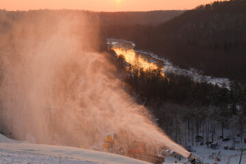 Panorama of the  mountains in the evening at the ski resort Sigulda, Latvia. River Gauja. Snow blower in action. Winter wonderland